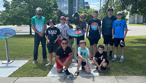 Campers and Jonathan Ashdown pose next to one of the Voyage display stations